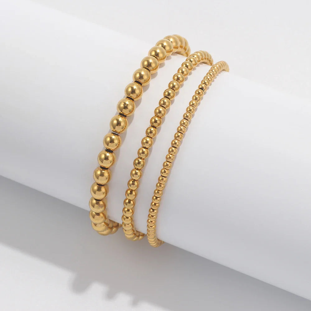 Set aus goldfarbenen Kugelarmbändern