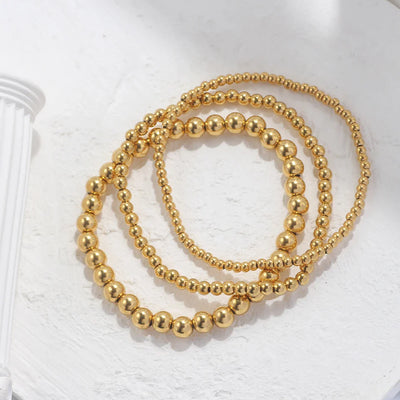 Set aus goldfarbenen Kugelarmbändern