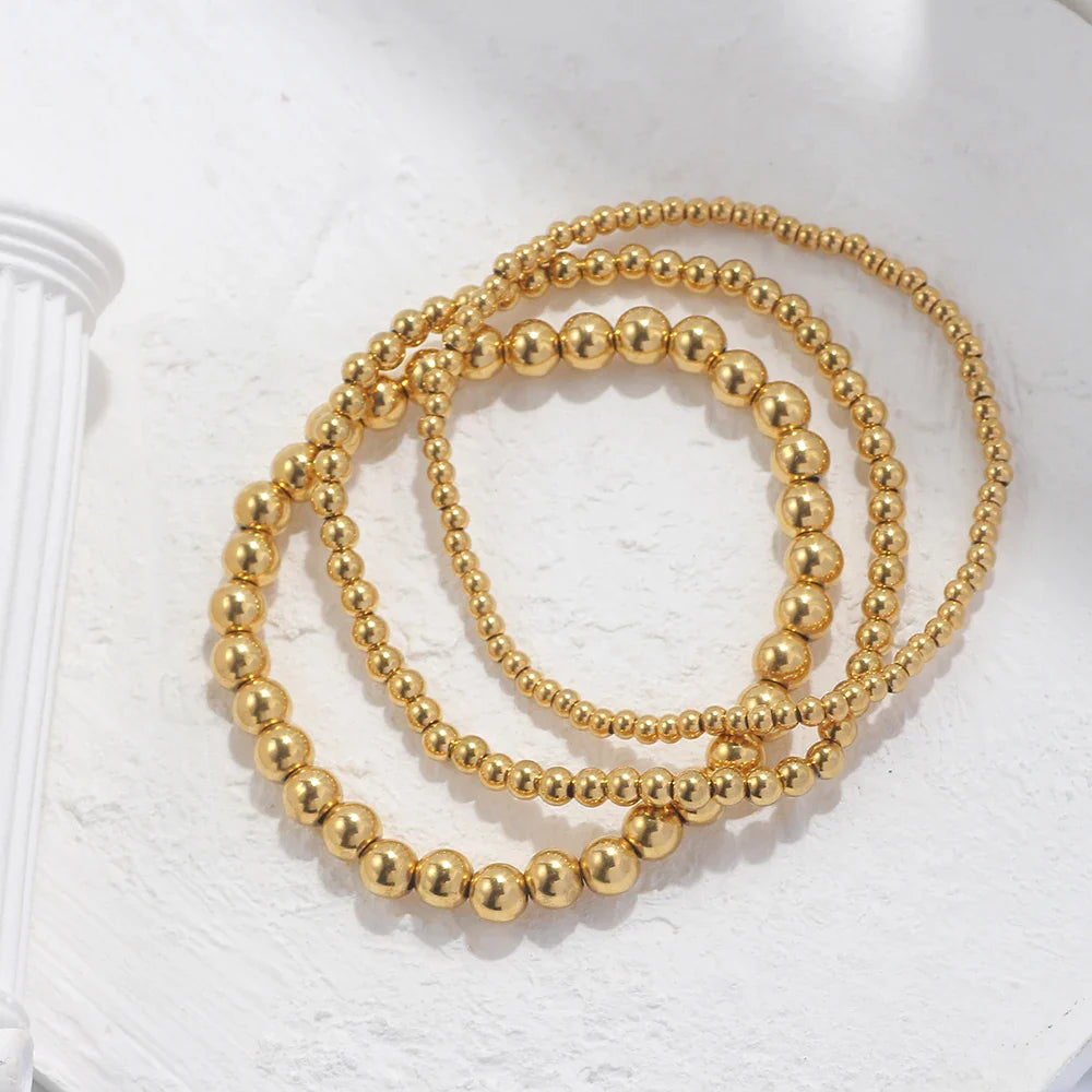 Set aus goldfarbenen Kugelarmbändern